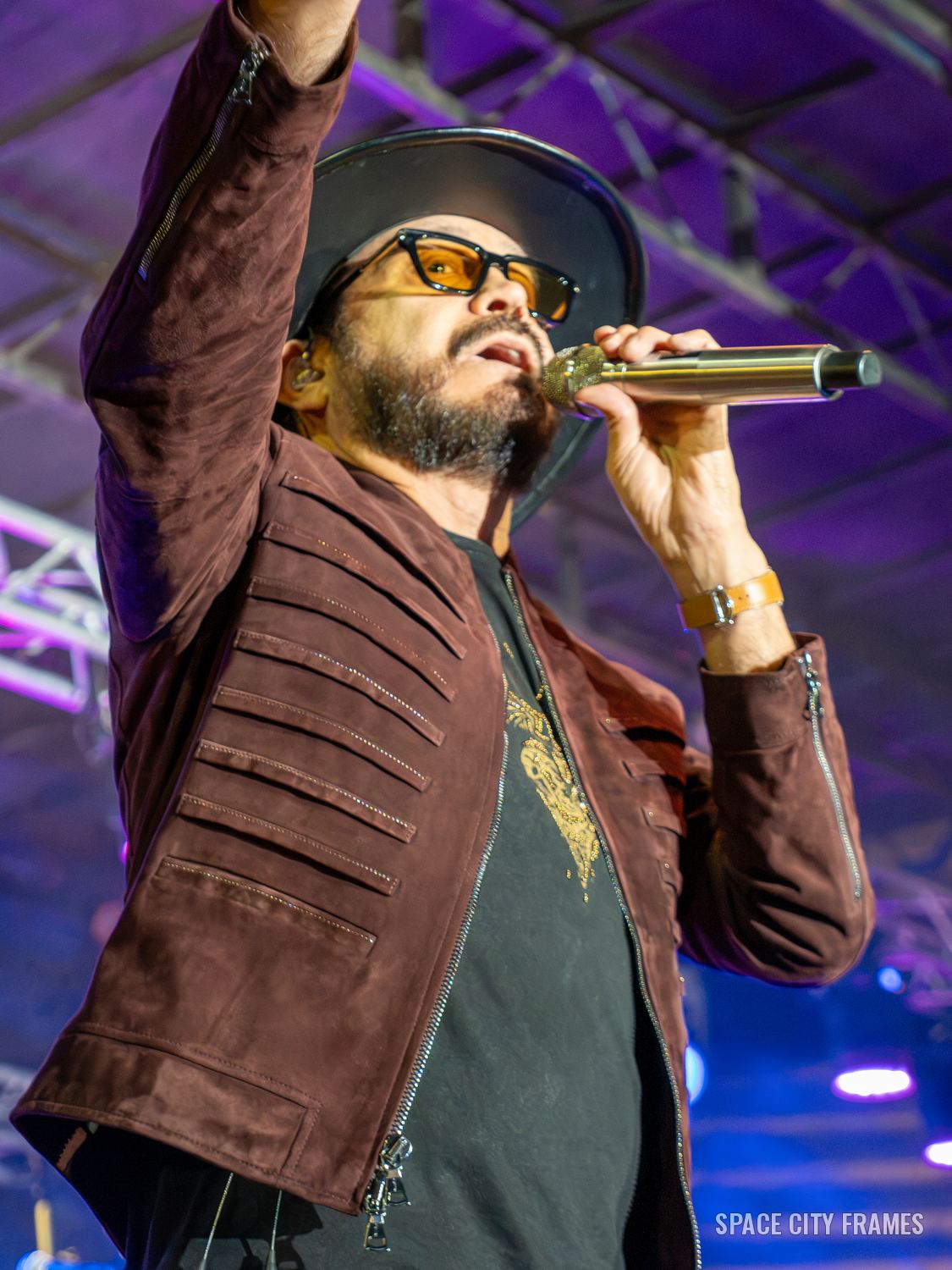 La Mafia: The singer with his arm raised and a gold microphone